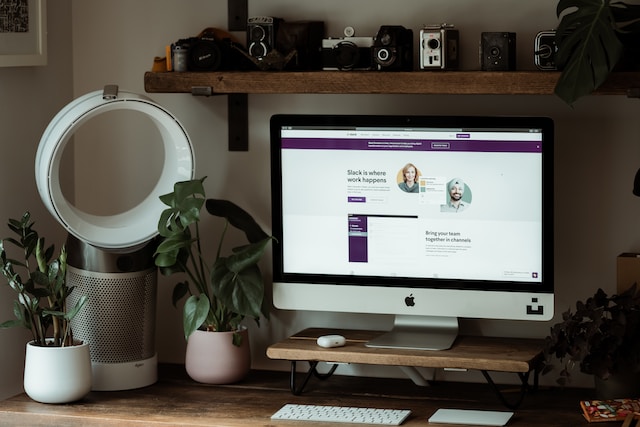 A computer monitor on a work desk with the Slack web browser on the screen