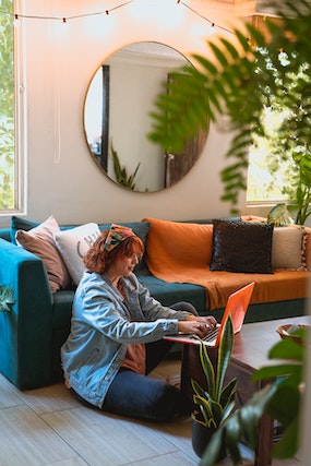 A woman works comfortably on the floor in her lounge