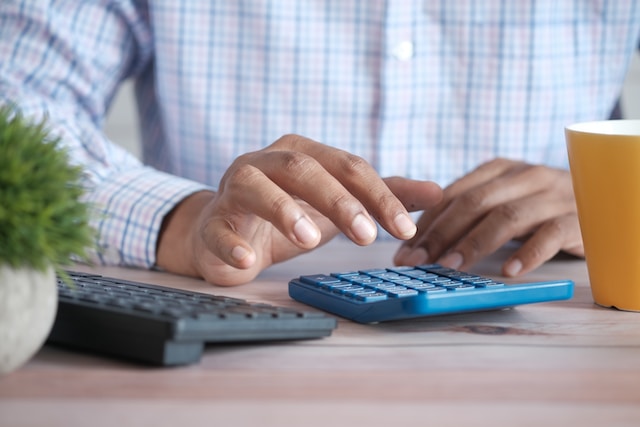 A person pressing buttons on a calculator